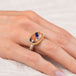 Gold and silver ring with an oval sodalite stone on a hand