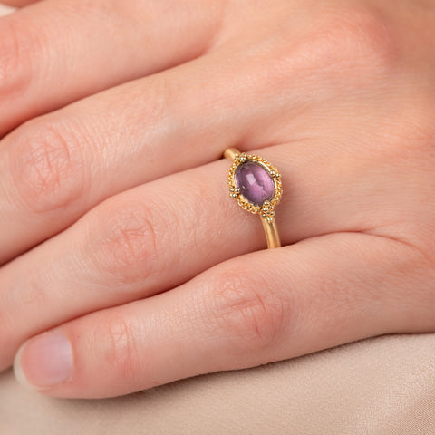 Gold ring with a spinel gemstone on a hand