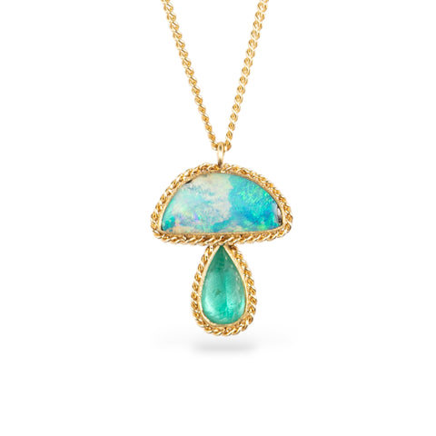 Gold necklace with a mushroom pendant featuring an opal and emerald stone on a white background
