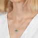 Gold necklace with mushroom pendant featuring boulder opal and aquamarine stones on a person