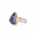 Handmade ring with a tanzanite gemstone, gold bezel and sterling silver band on a white background
