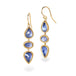 Gold earrings with a trio of tanzanite stones on a white background
