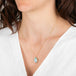 Necklace with a teardrop-shaped Ethiopian Opal pendant worn by a person in a white top