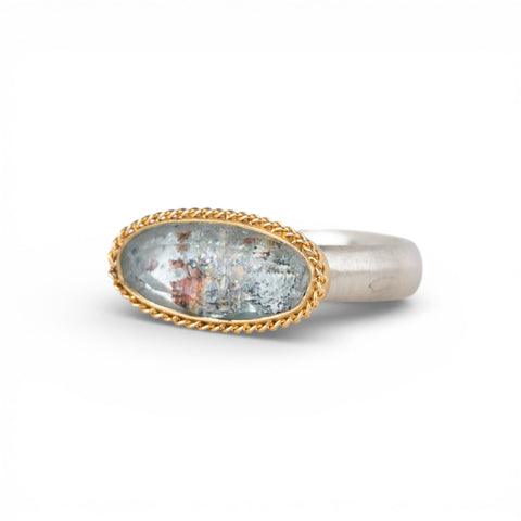 Gold and silver ring with topaz stone on a white background