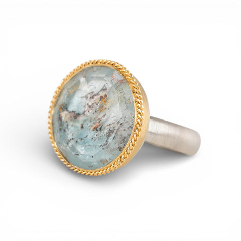 Silver and gold ring with topaz stone on a white background