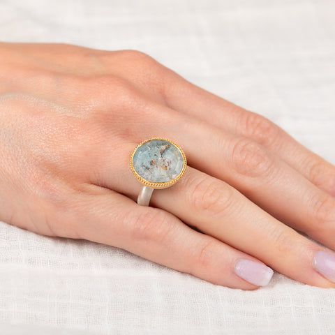 Silver and gold ring with topaz stone on a hand