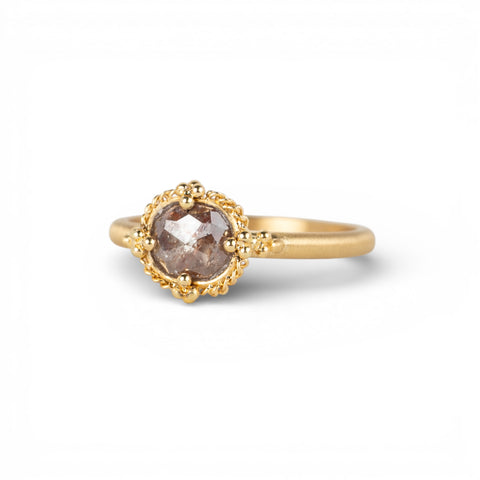 Gold ring with a brown diamond on a white background