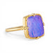 Gold ring with a purple boulder opal stone on a white background