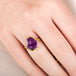 Gold ring with an amethyst gemstone on a hand