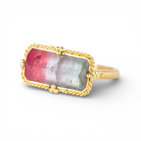 Gold ring with a colorful watermelon tourmaline gemstone on a white background