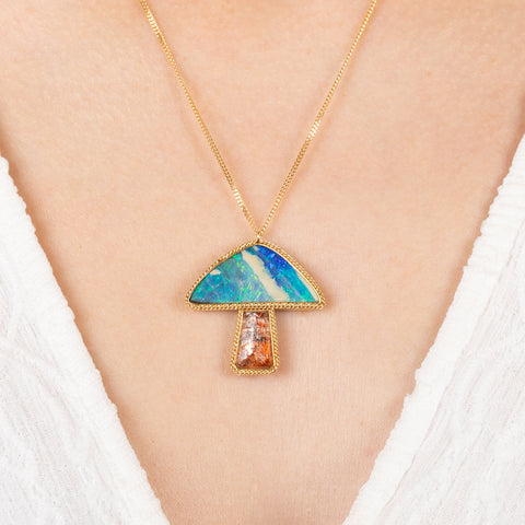 Mushroom necklace with a colorful pendant on a person wearing a white top