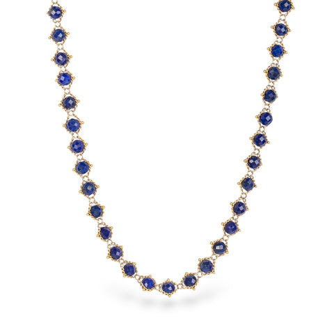 Gold chain necklace with lapis gemstones on a white background