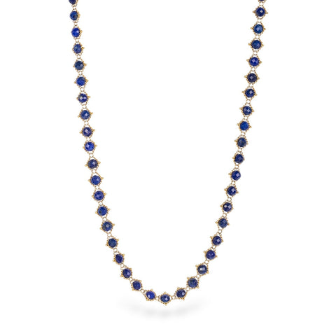 Gold chain necklace with lapis gemstones on a white background