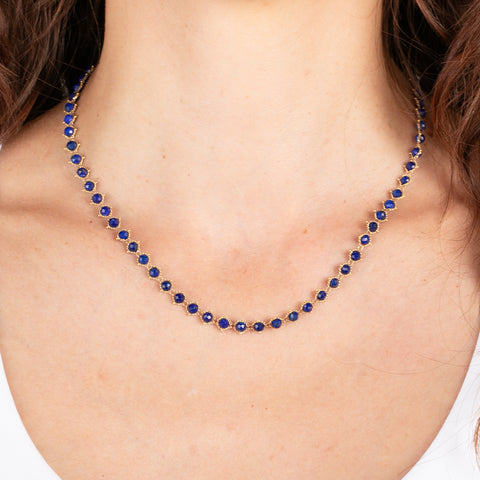Gold chain necklace with lapis gemstones on a person