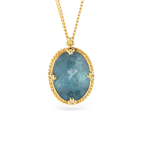Gold necklace with an oval aquamarine gemstone pendant on a white background