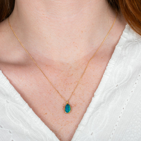A model wears an australian opal doublet and 18k yellow gold necklace.