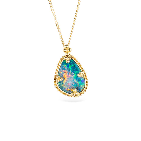 Australian opal doublet and 18k gold necklace on a white background