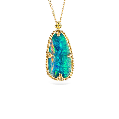 Australian opal doublet and 18k yellow gold necklace on a white background.