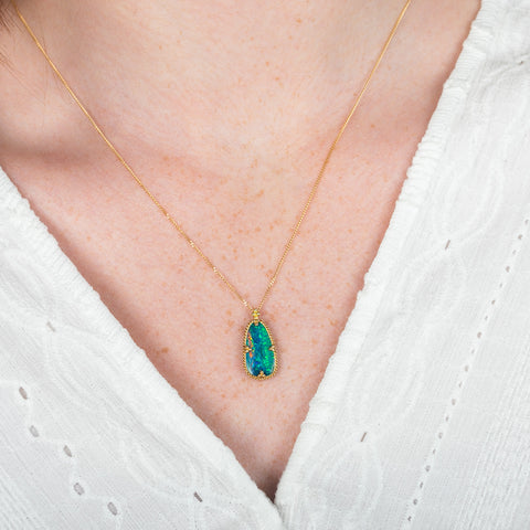 A model wears an australian opal doublet and 18k yellow gold necklace.