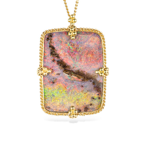 18k yellow gold and boulder opal gemstone necklace on a white background.