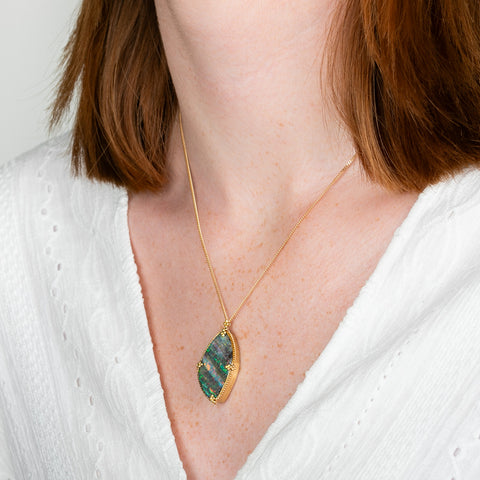 A model wears a boulder opal and 18k yellow gold necklace.