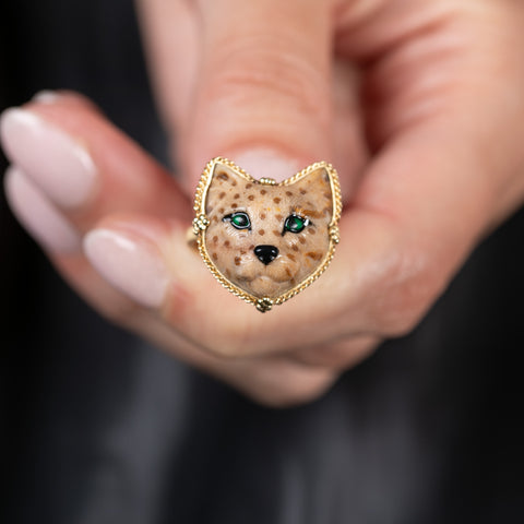 A model holds a handmade 18k yellow gold and leopard jasper cat ring.