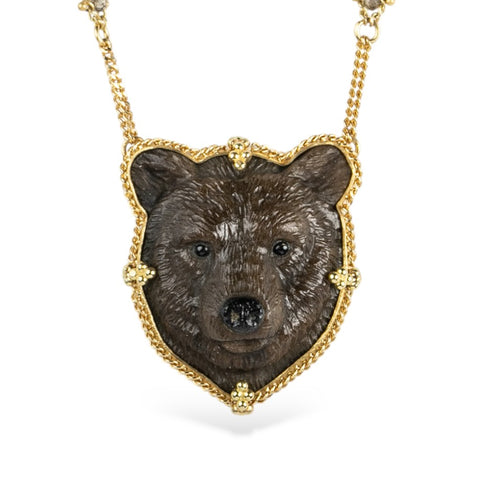Handmade necklace featuring a jasper stone carved into a grizzly bear and set in 18k yellow gold. It is strung on an 18k gold chain embellished with a row of diamonds on each side.