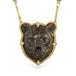 Handmade necklace featuring a jasper stone carved into a grizzly bear and set in 18k yellow gold. It is strung on an 18k gold chain embellished with a row of diamonds on each side.