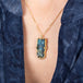 Carved Labradorite Owl Necklace on model side view blue shirt