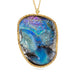 A necklace featuring a boulder opal gemstone carved into the portrait of a woman with flowers in her hair, set in an 18k yellow gold bezel and strung from an 18k yellow gold chain.