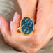 Carved labradorite ring held in hand