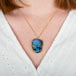 A model wears a carved boulder opal gemstone and 18k yellow gold necklace.