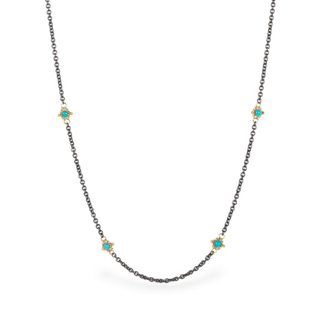 Oxidized silver chain necklace with turquoise gemstone beads encircled in 18k yellow gold.