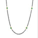 A necklace with oxidized sterling silver chains featuring woven 18k gold strands with Emeralds, displayed on a white background.