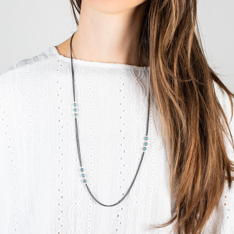 Oxidized silver and gold necklace with london blue topaz on a model