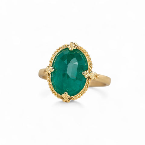 Handmade 18k yellow gold and oval-shaped emerald gemstone ring.