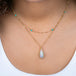 A model wears a handmade ethiopian opal and 18k gold necklace paired with a turquoise and 18k gold chain necklace.