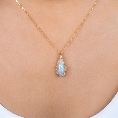 A model wears a handmade ethiopian opal and 18k gold necklace.