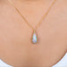 A model wears a handmade ethiopian opal and 18k gold necklace.