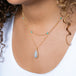A model wears a handmade ethiopian opal and 18k gold necklace paired with a turquoise and 18k gold chain necklace.