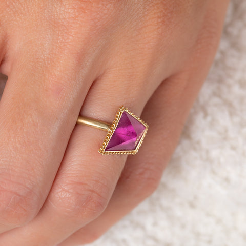 Pink tourmaline and gold ring on model side view
