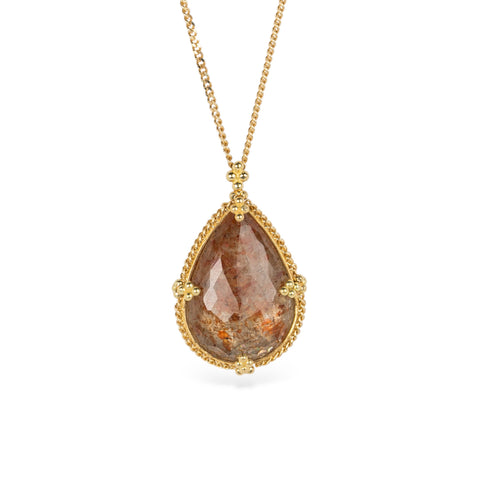 A teardrop-shaped Spessartite gemstone necklace set in a gold bezel, suspended from an 18k gold chain.