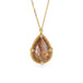 A teardrop-shaped Spessartite gemstone necklace set in a gold bezel, suspended from an 18k gold chain.