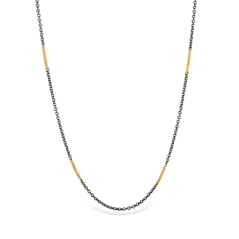Necklace featuring alternating lengths of oxidized sterling silver and 18k gold chain.