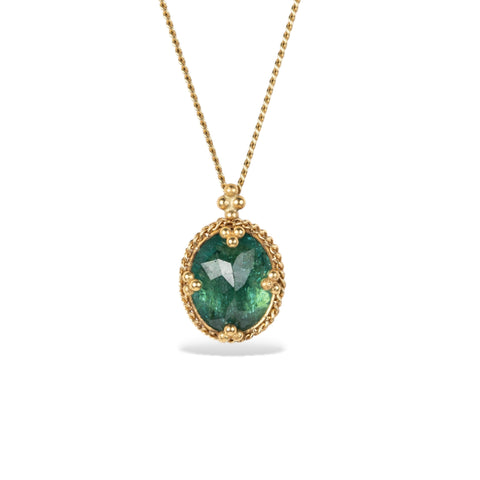 Green tourmaline and gold necklace on white background