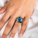 A model wears a square-shaped Labradorite gemstone ring set in a handcrafted 18k yellow gold bezel.