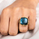 A model wears a square-shaped Labradorite gemstone ring set in a handcrafted 18k yellow gold bezel.