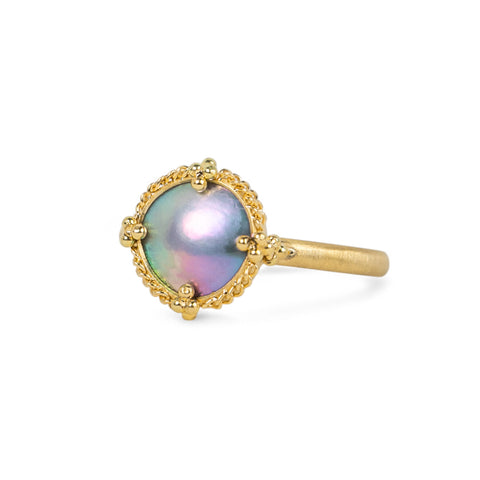 A mabe pearl ring with an 18k gold setting and band, shown against a white background.