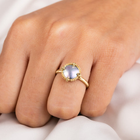 A model wears a handmade mabe pearl and 18k yellow gold ring.