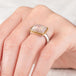 A person wears a handcrafed ring featuring a mexican opal gemstone in an 18k gold setting with a sterling silver band